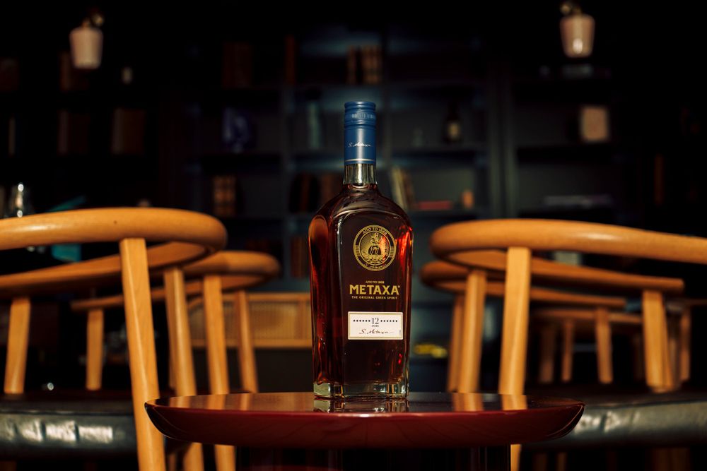A bottle of Metaxa sitting in a rustic library