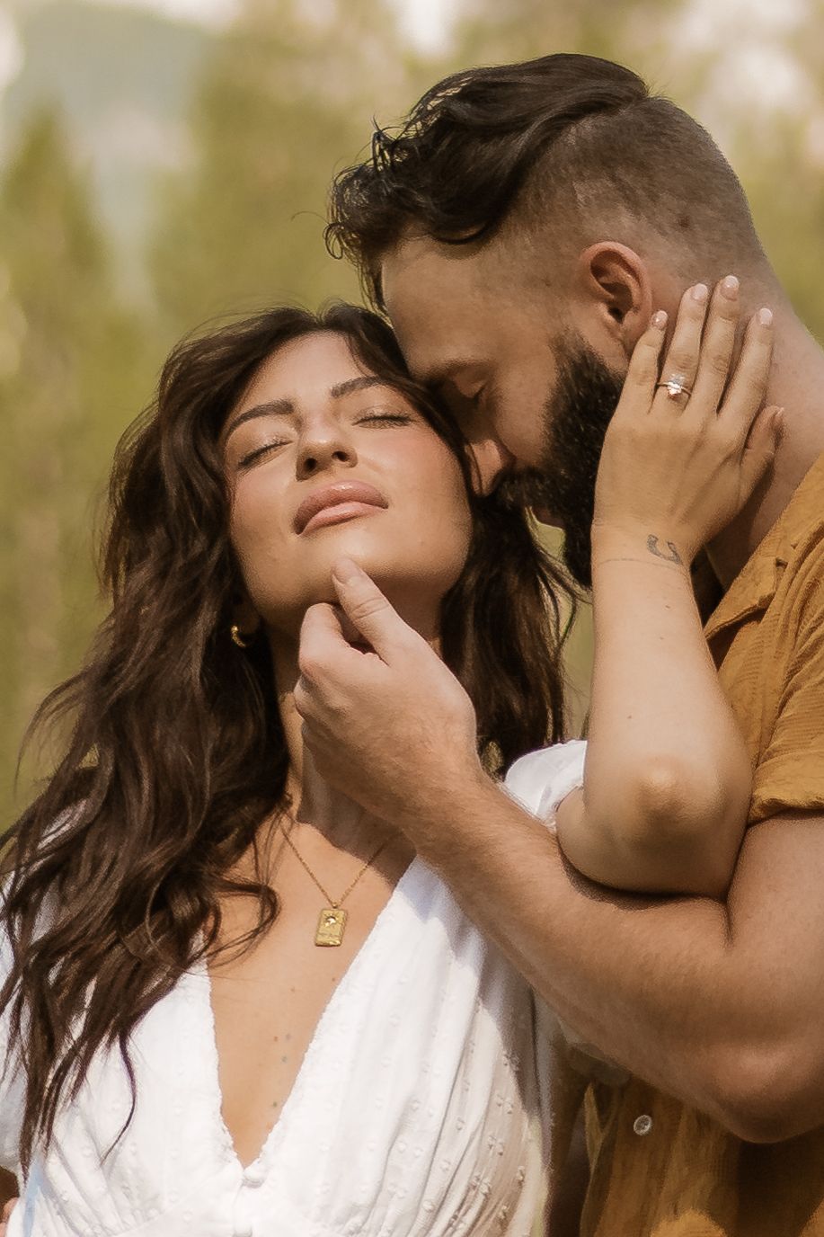 An intimate close-up moment between two people in warm natural lighting.