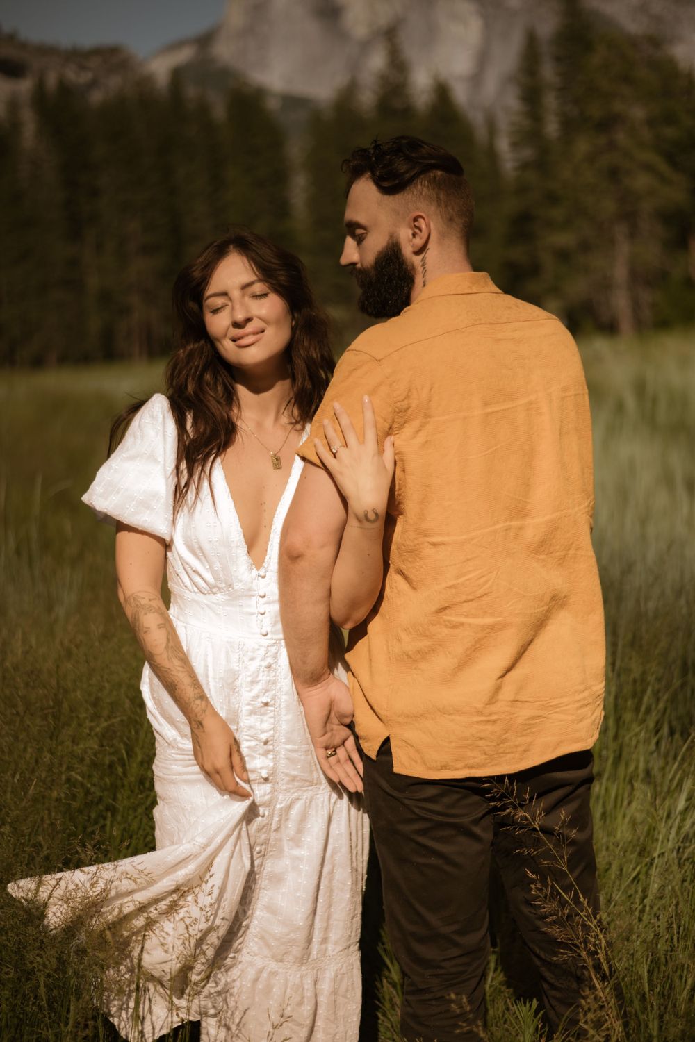 Romantic photoshoot in a meadow with a white dress flowing in the mountain breeze.