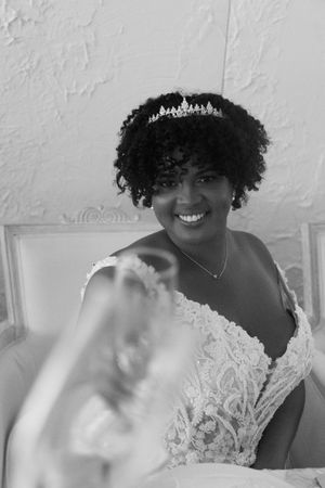 A beautiful wedding portrait showing a joyful smile and delicate lace dress with tiara.