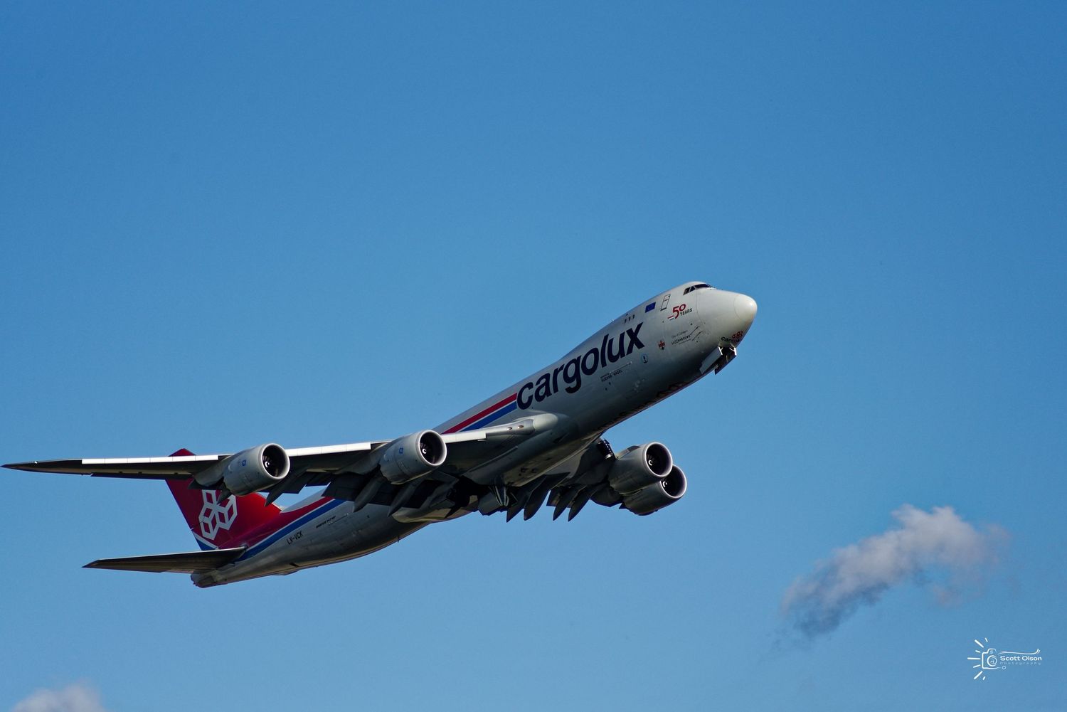 Cargolux Boeing 747 aircraft ascending against clear blue sky just after takeoff.