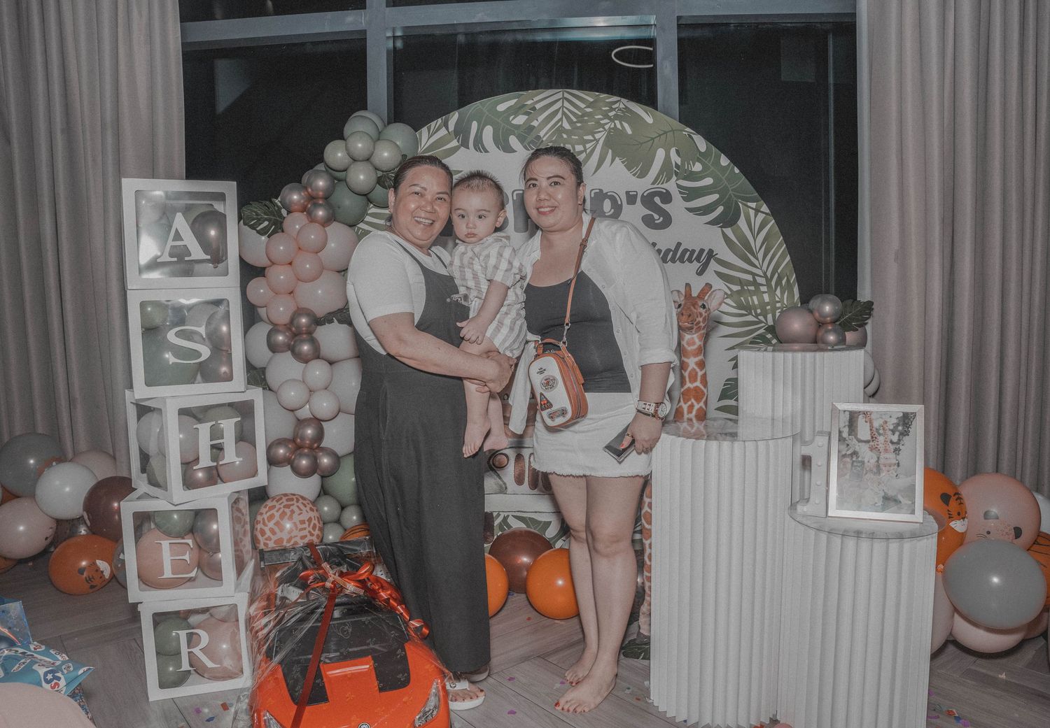 Family celebration with balloon arch decoration and photo display.