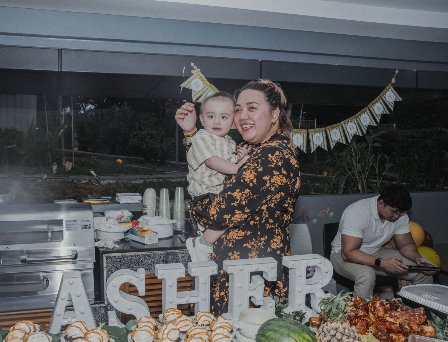 Celebration setup with decorative letters spelling ASHER and festive party decorations.