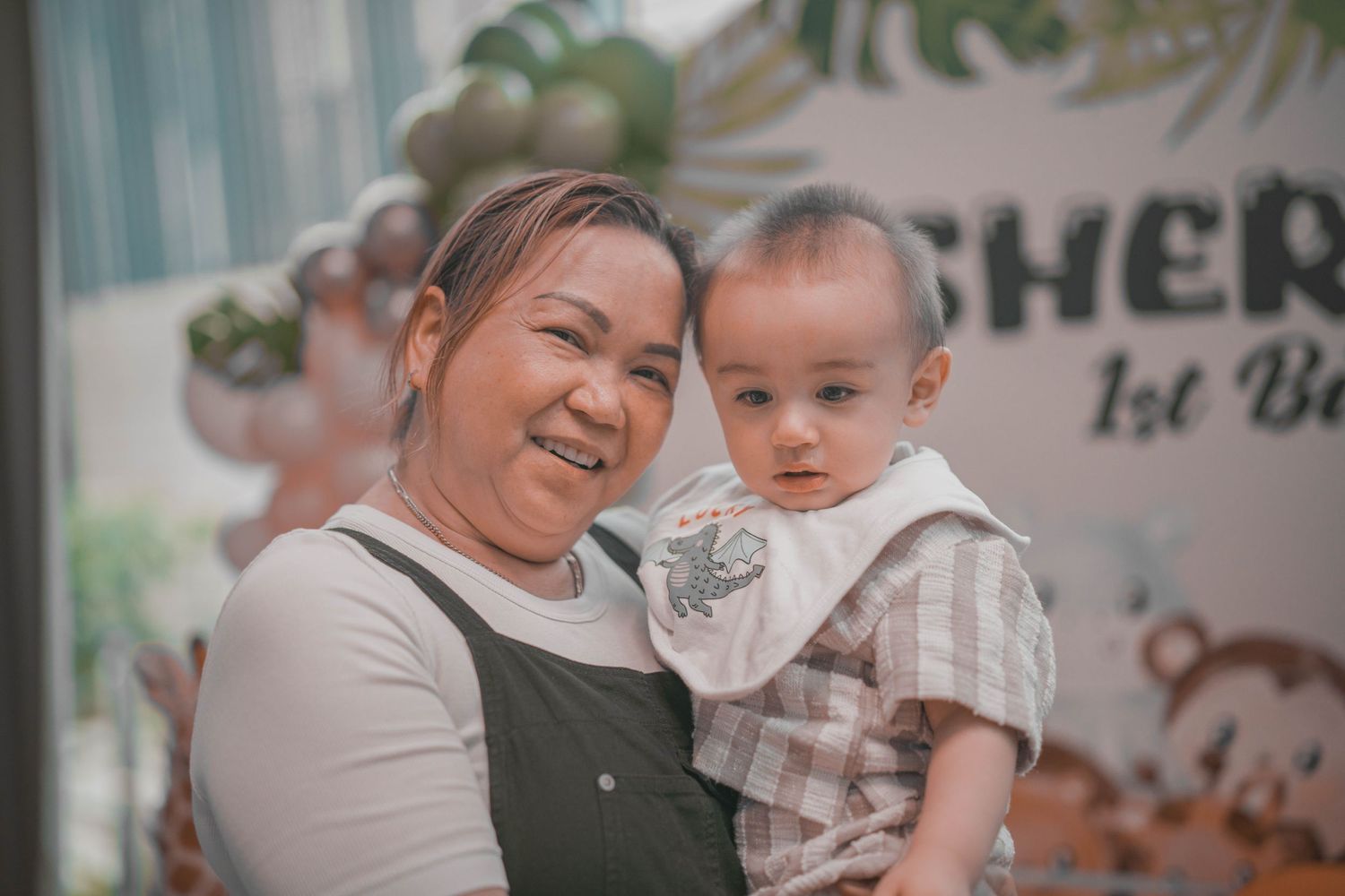 Heartwarming moment at a first birthday celebration with tropical-themed decorations.