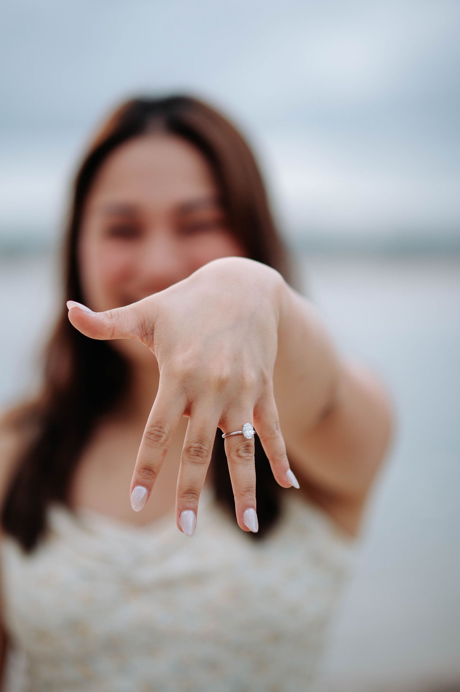 Close up of engagement ring on hand with blurred background.