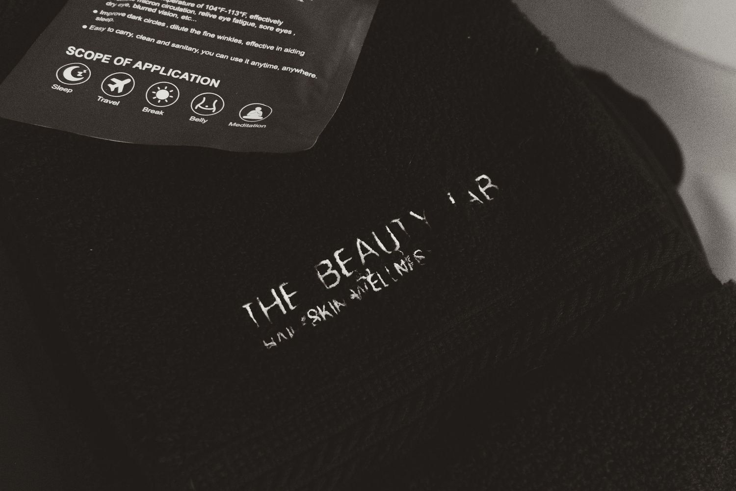 Black t-shirts with white text designs hang on a retail clothing rack display.