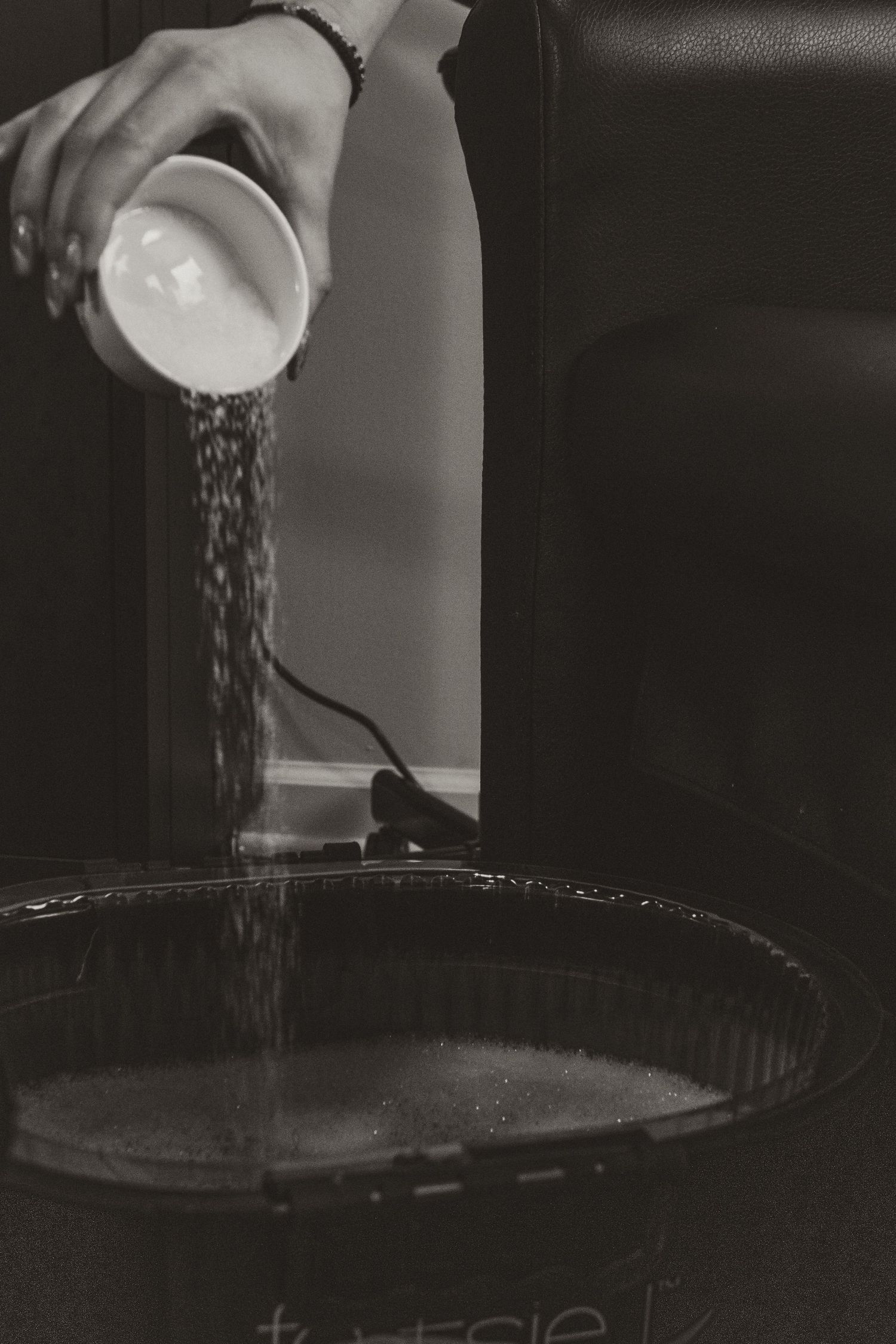 Water being poured into a dark surface creating circular ripples and splashes in dramatic lighting.
