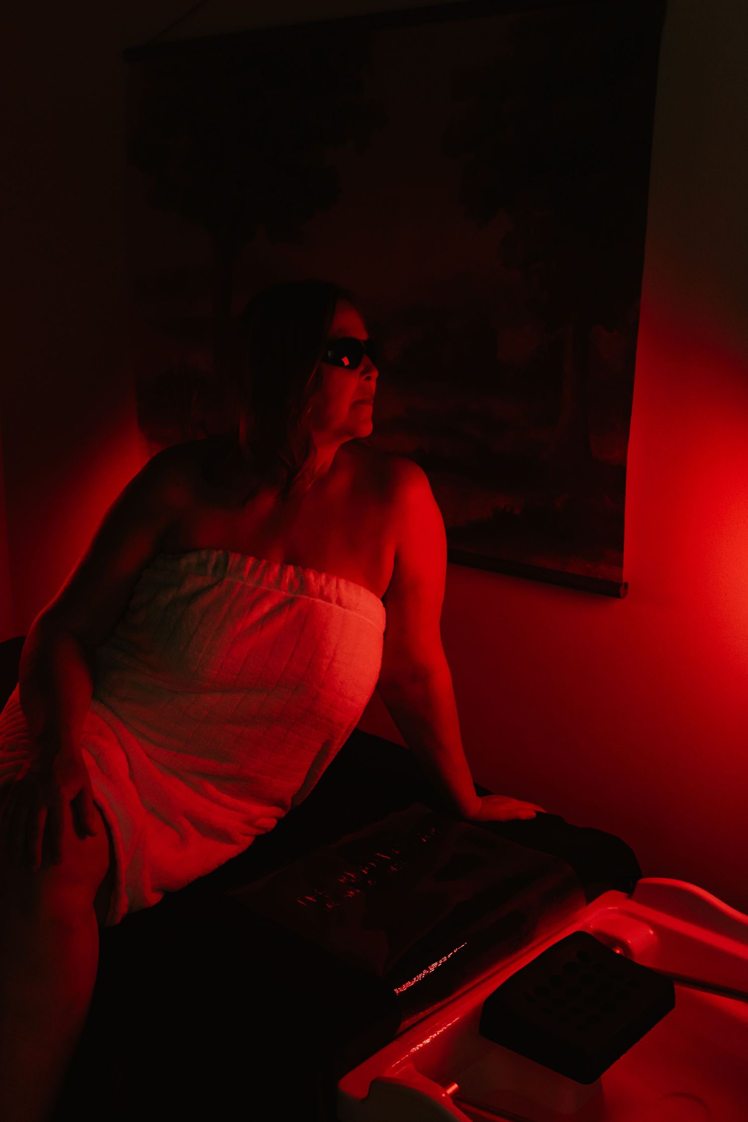 A series of dark images with red lighting showing someone working at a desk in low-light conditions.