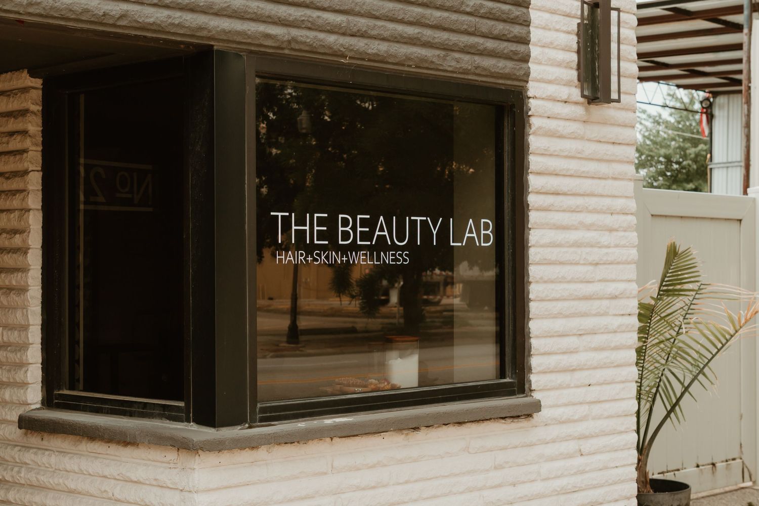 Modern beauty salon storefront with white brick exterior and large windows displaying 'The Beauty Lab' signage.