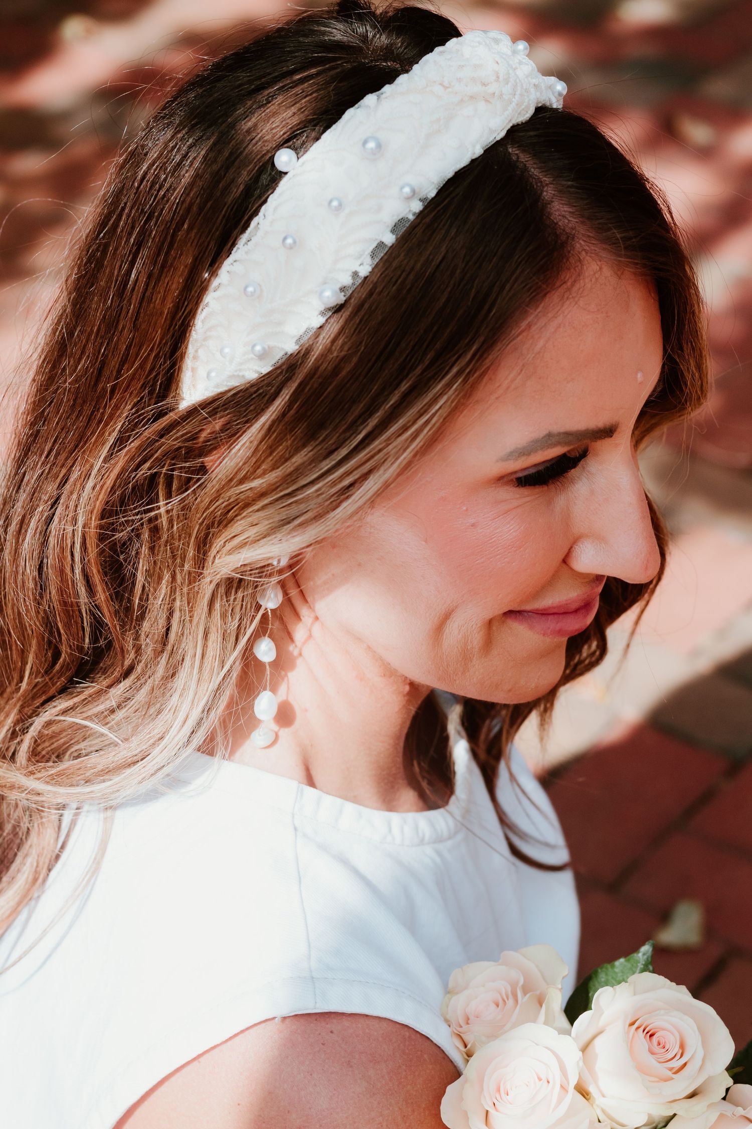 Pearl-studded white headband detail with soft peachy roses.