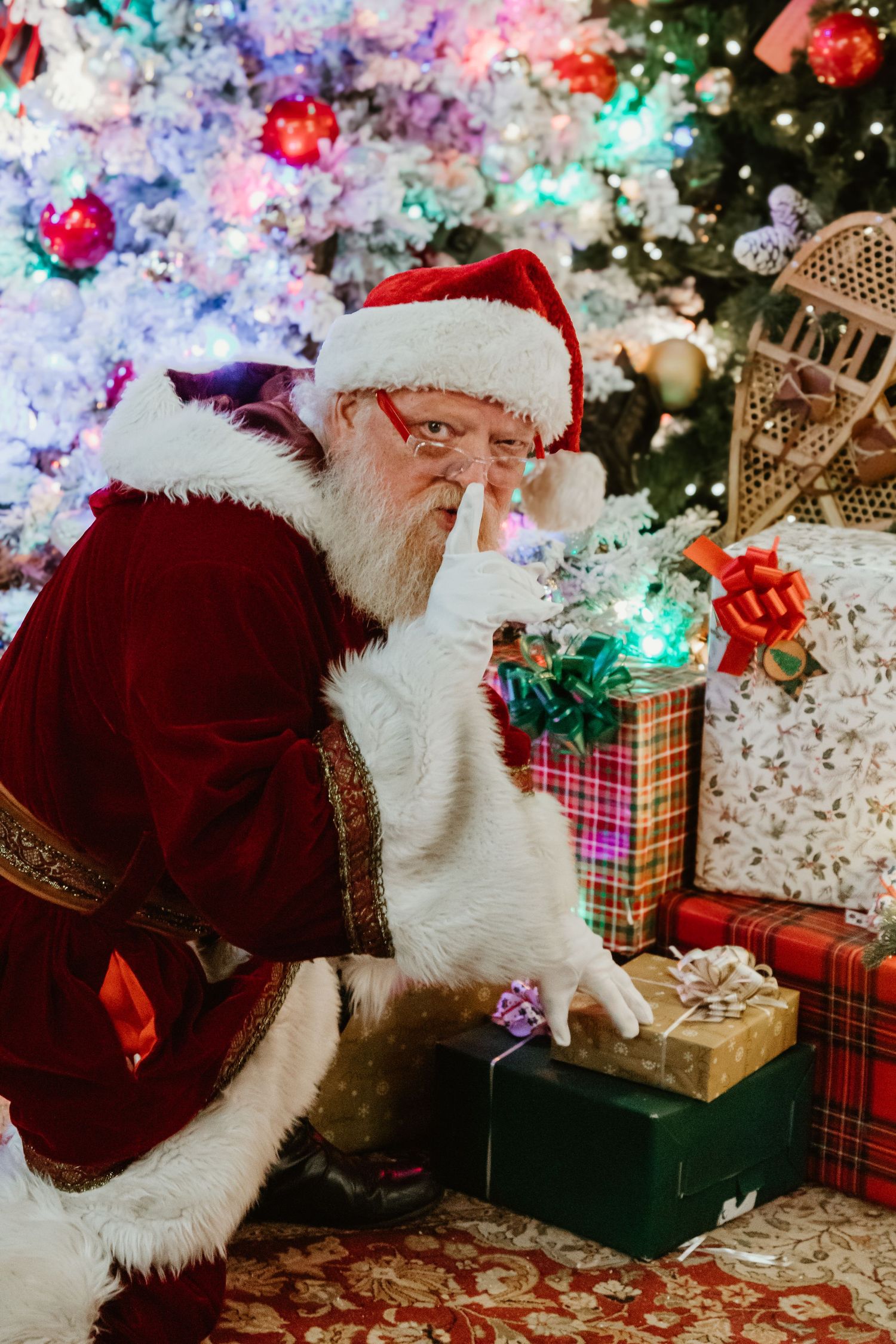 Festive scene with presents and colorful lights surrounding figure in traditional holiday costume.