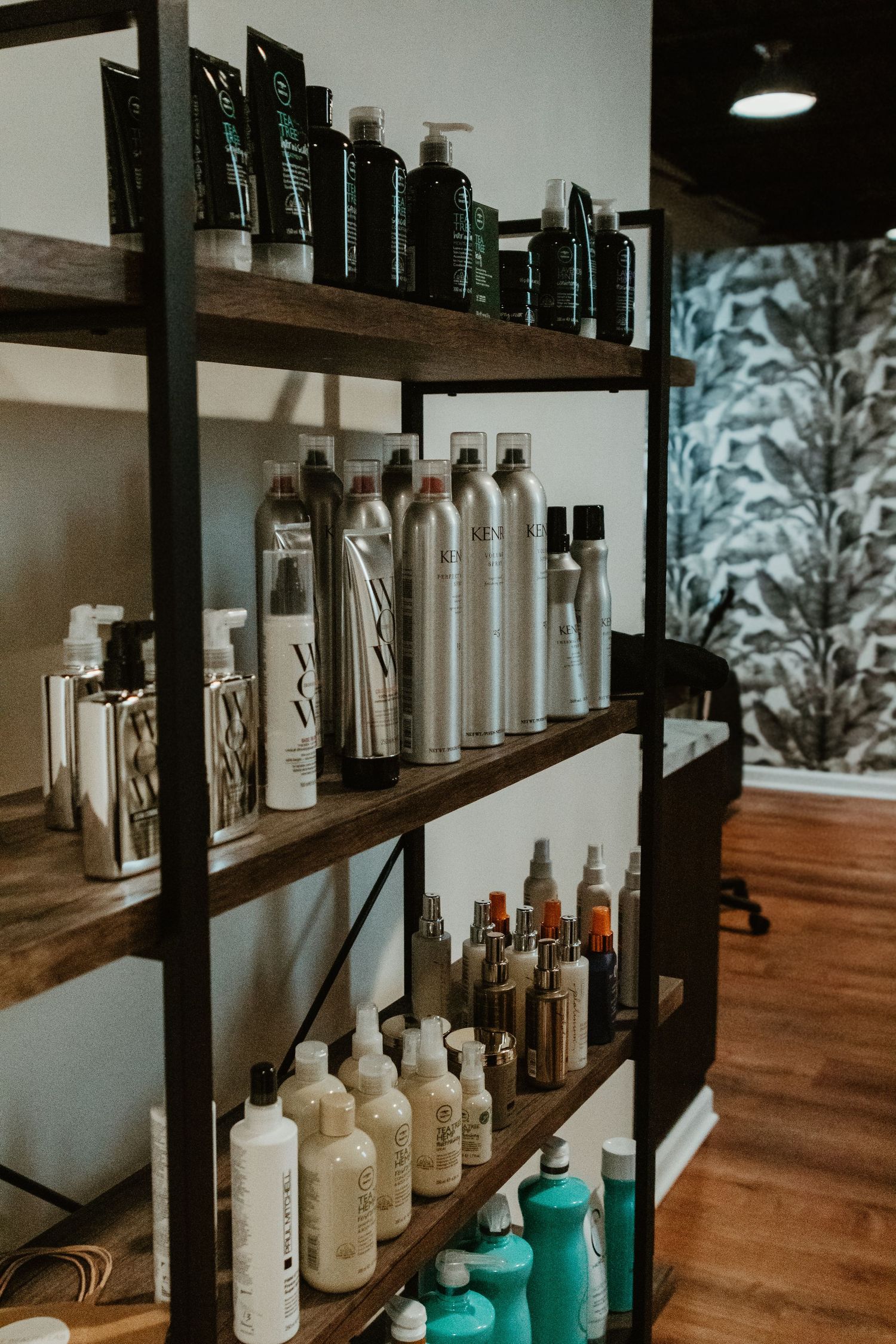 Wooden shelves displaying various hair care products and bottles in a salon setting.