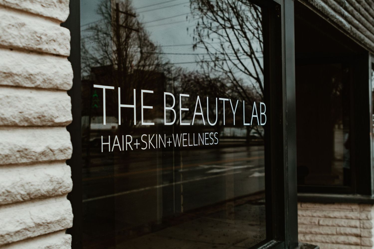Storefront window with 'THE BEAUTY LAB HAIR+SKIN+WELLNESS' signage.
