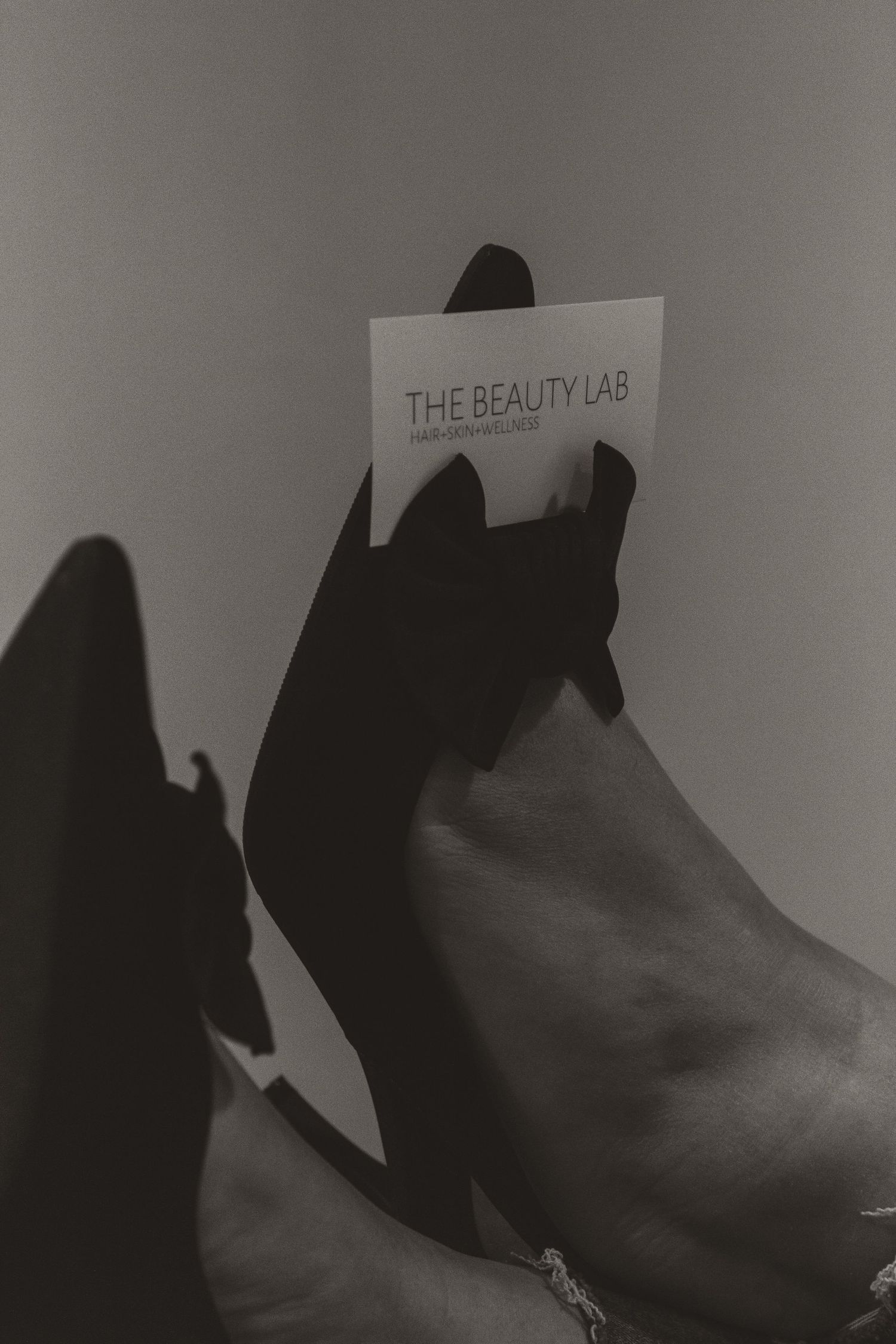 Artistic black and white photo holding a beauty lab business card.