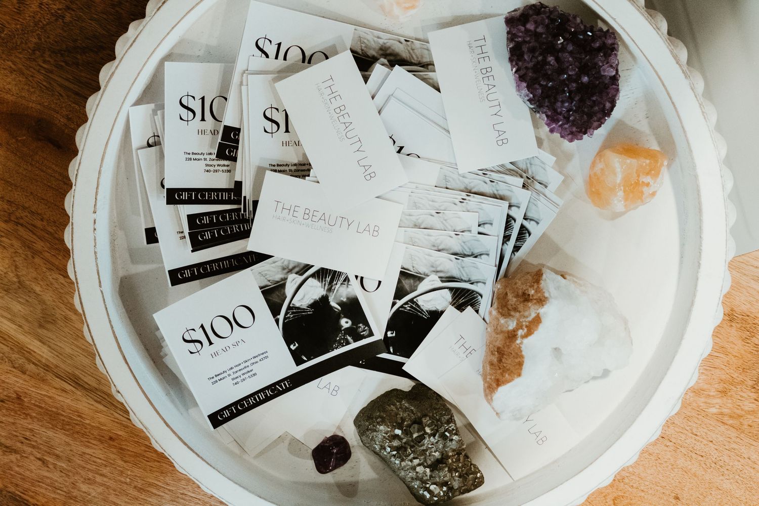 Collection of gift cards and crystals arranged on white circular tray.