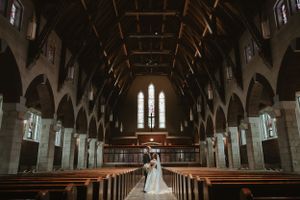 Stunning wedding photo in a grand gothic church with dramatic wooden beams and vaulted ceiling. Wedding photographer Johnstown Somerset PA