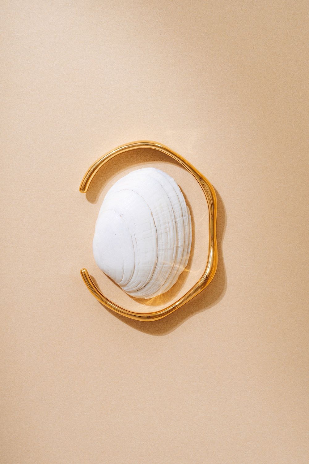 A series of five images showing a white volleyball progressively fading into a beige background.