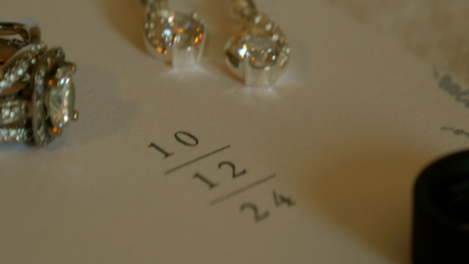 A wedding date is written on paper with sparkly decorations visible.
