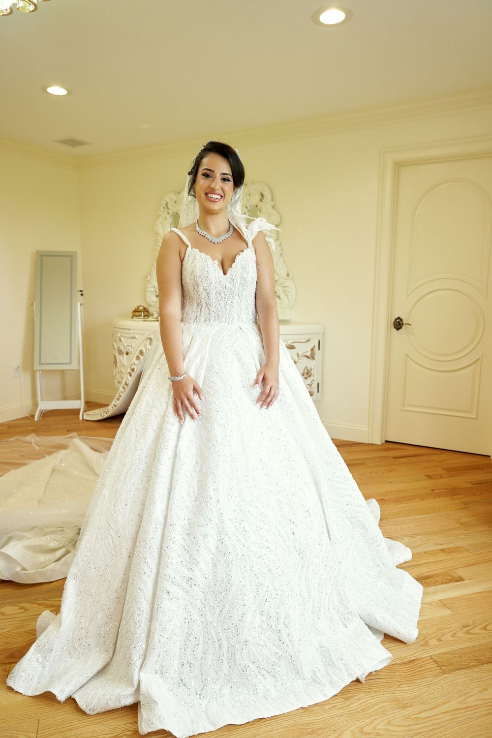 Bridal gown fitting session showing full ballgown style dress in sunlit room.