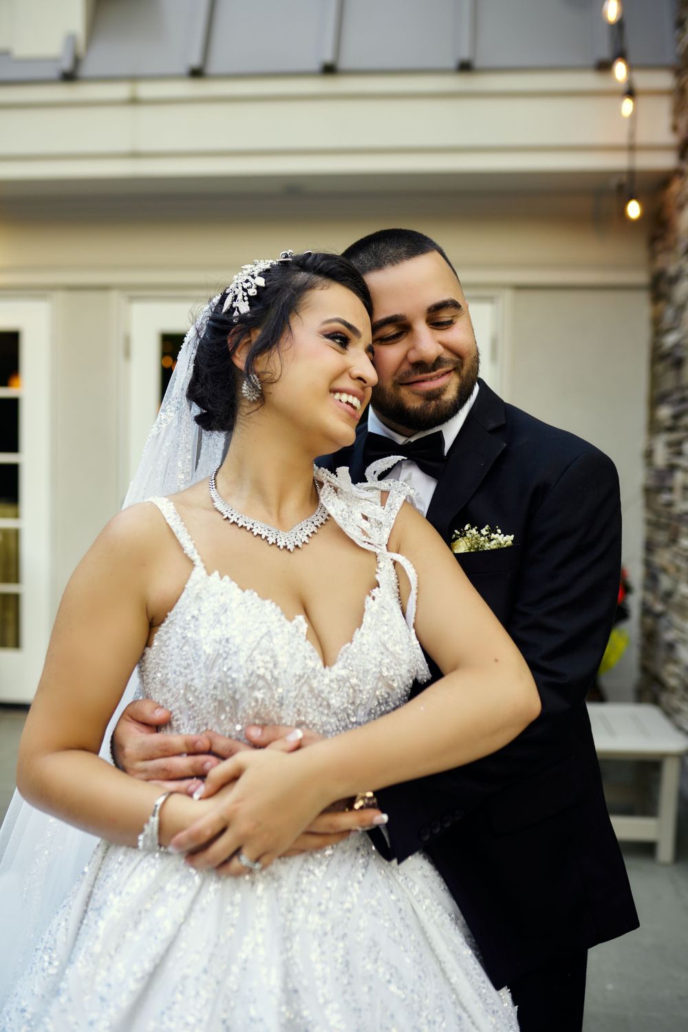 A romantic wedding portrait showcasing a sparkly ball gown and classic black tuxedo.