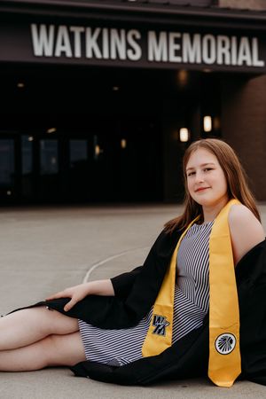 A graduation photo series showing someone in a black gown and gold sash posing on the ground near Watkins Memorial.