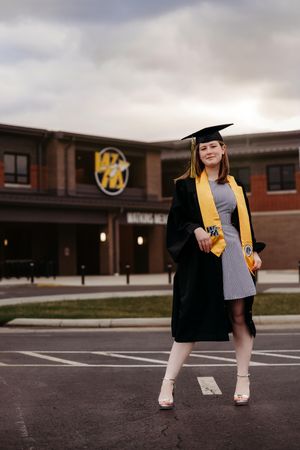 A graduation photo series shows a graduate in black gown and gold stole walking across a parking lot at dusk.