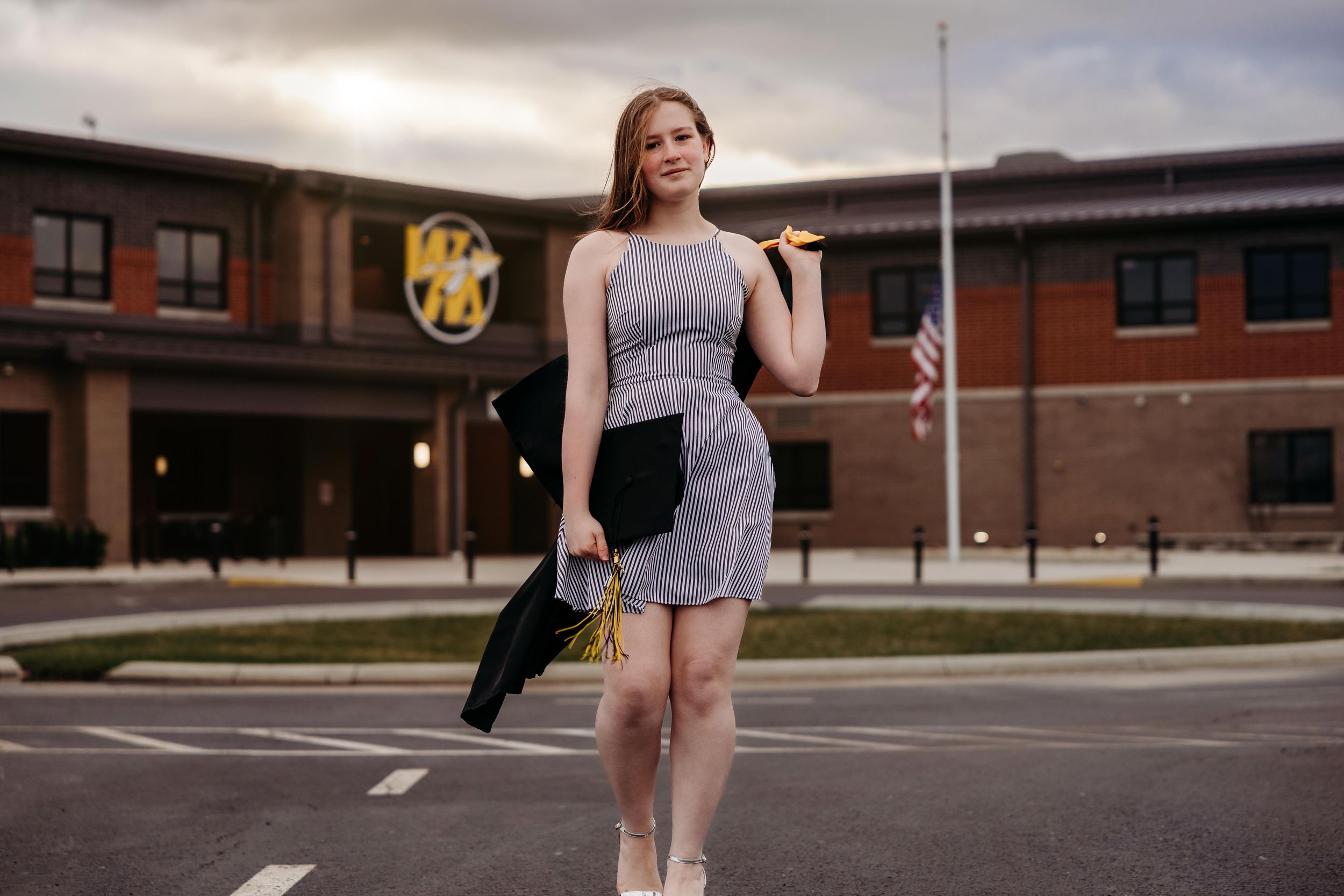 A dancer performs graceful ballet poses against a modern building exterior.