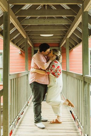 A romantic scene in a covered wooden walkway with white and coral tones.