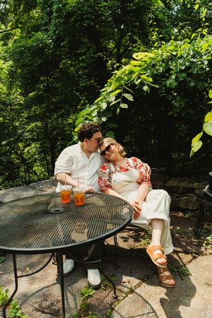 A sequence of tender moments captured on an outdoor metal bench surrounded by lush greenery.
