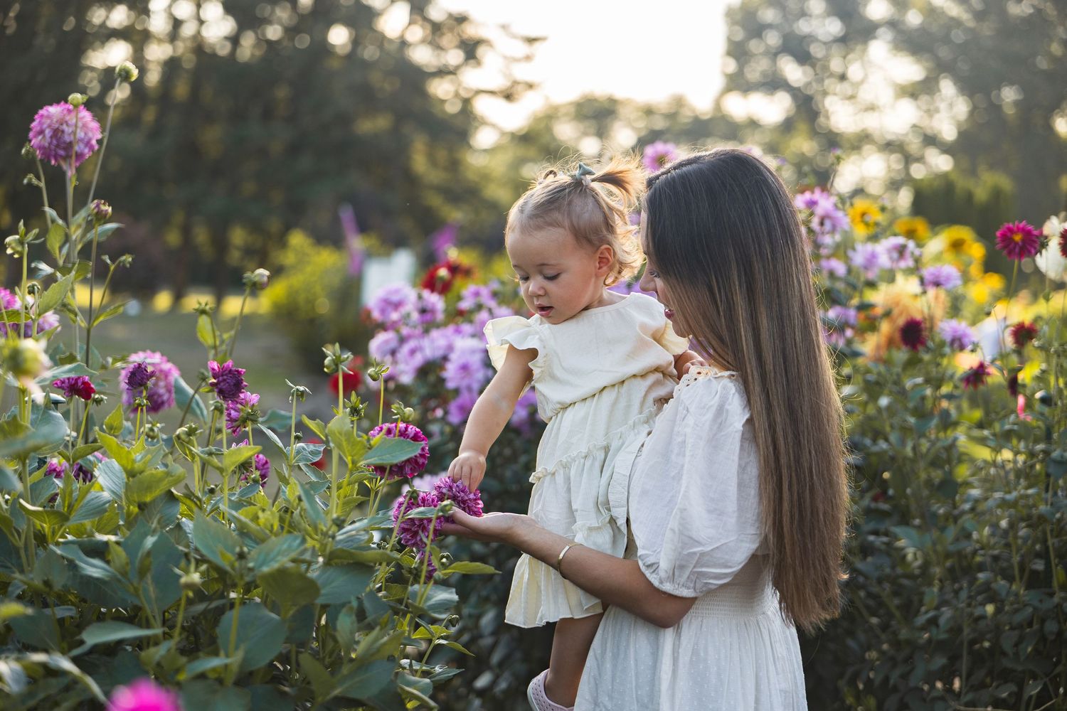 Family enjoying time together in a garden with blooming purple and pink flowers.