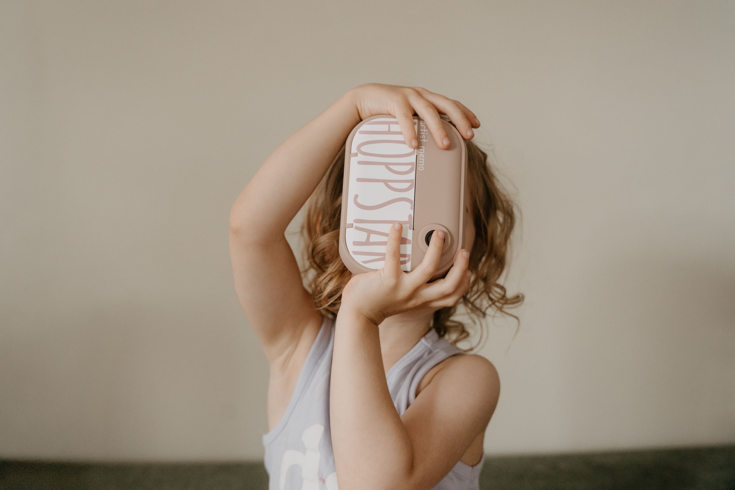 Person in white tank top holds a cup against their face in a series of artistic portrait shots.