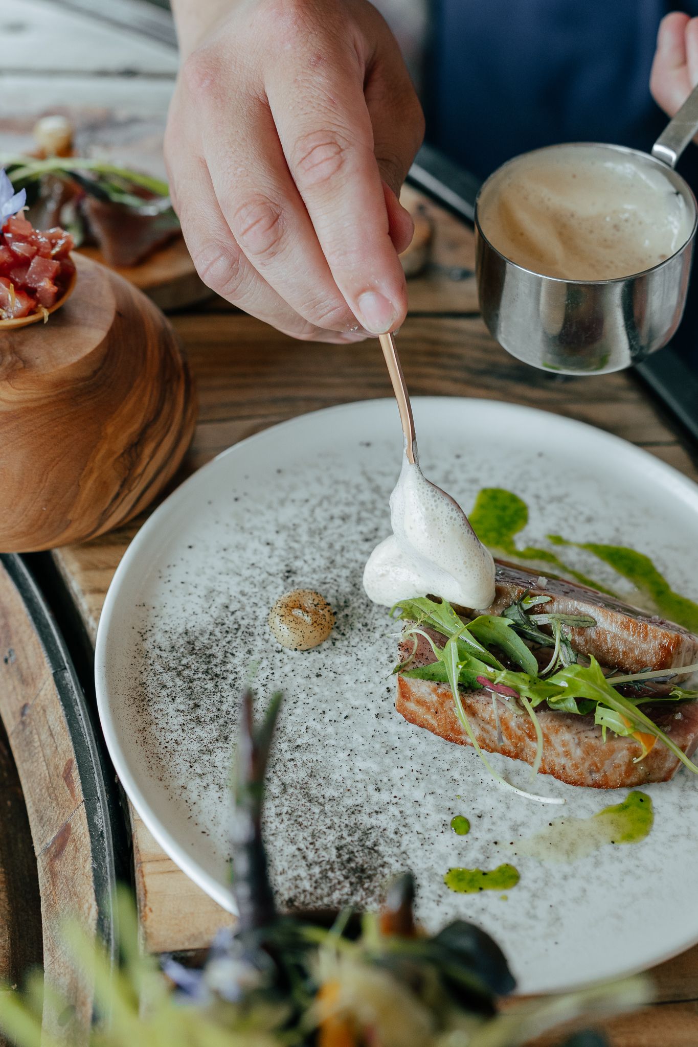 Chef en assiette de saumon gastronomique avec sauce à la crème sur assiette blanche dans un cadre de restaurant haut de gamme.