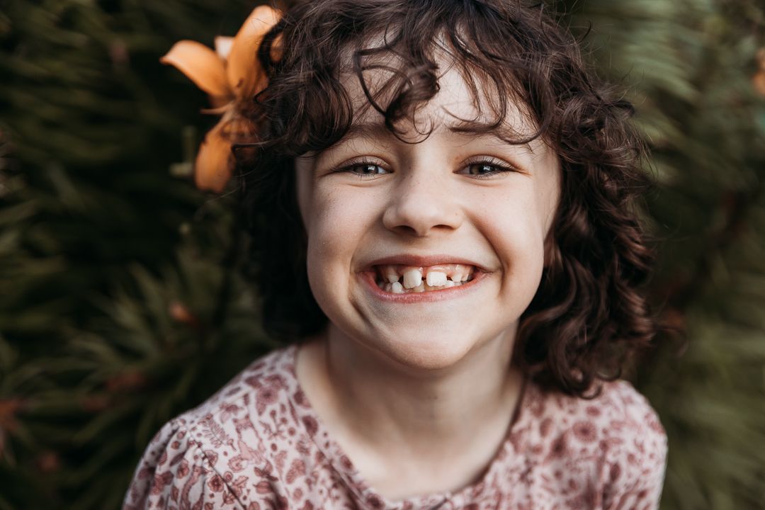 A sequence of seven close-up portraits showing a child with curly hair and a pink dress expressing joyful emotions.