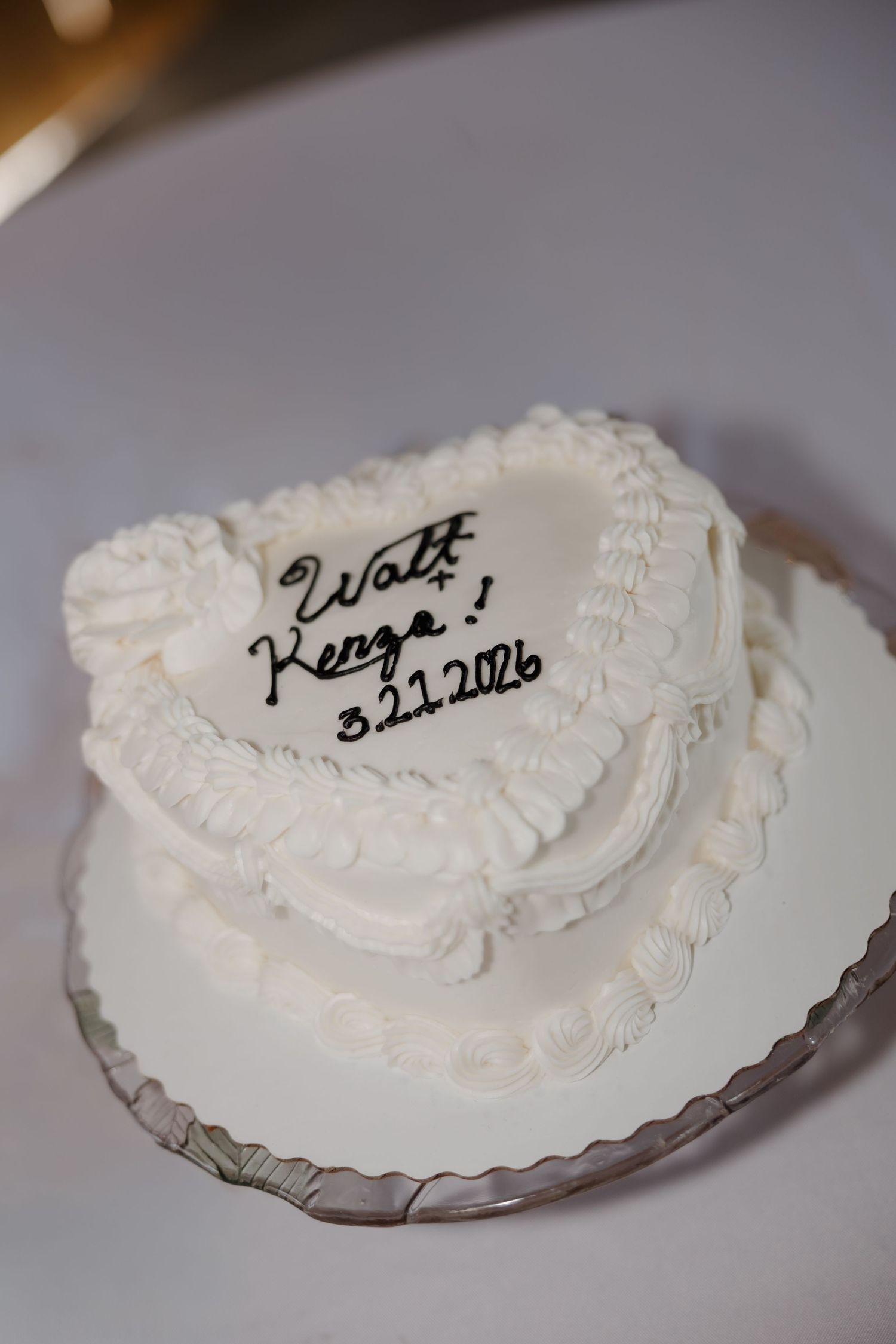 Close-up shots of a white frosted wedding cake with handwritten message.