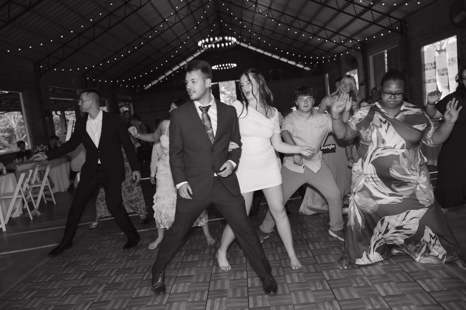 Vintage black and white photograph of people dancing at a social gathering in an indoor venue.