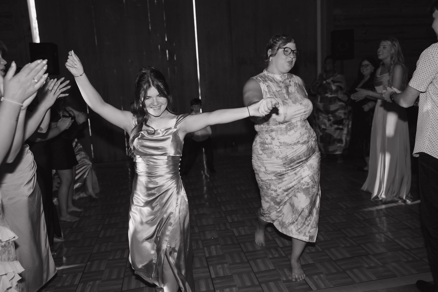 A group of people dancing and celebrating at what appears to be a lively wedding reception or party.