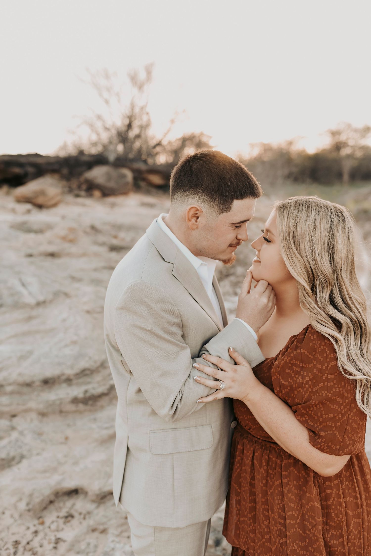 Engagement photos in a scenic field near Grapevine Lake at sunset.