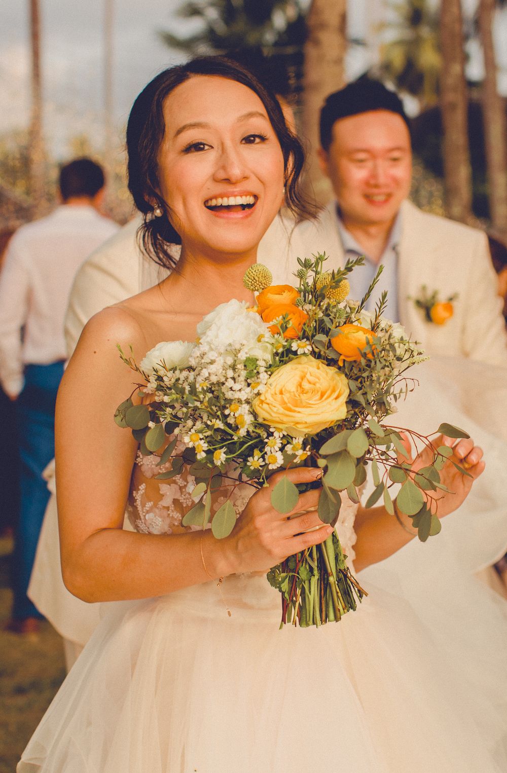 Bride holding bouquet and smiling at groom during intimate beach wedding in Koh Samui