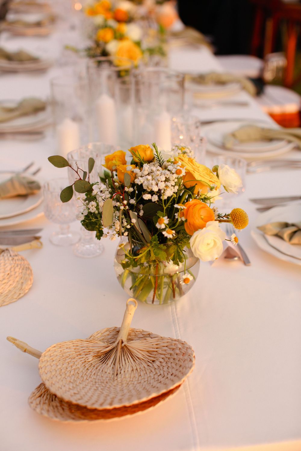 Wedding table setting with floral centerpiece and woven fan details at a Koh Samui beach reception