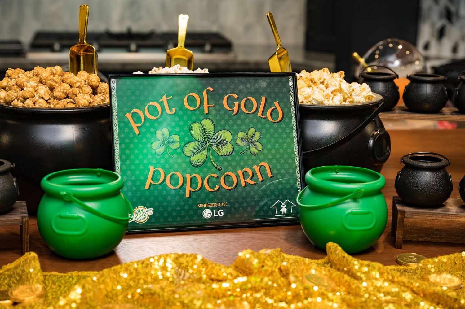 Pot of Gold Popcorn station with black cauldrons and gold decorations at a St. Patricks Day event.