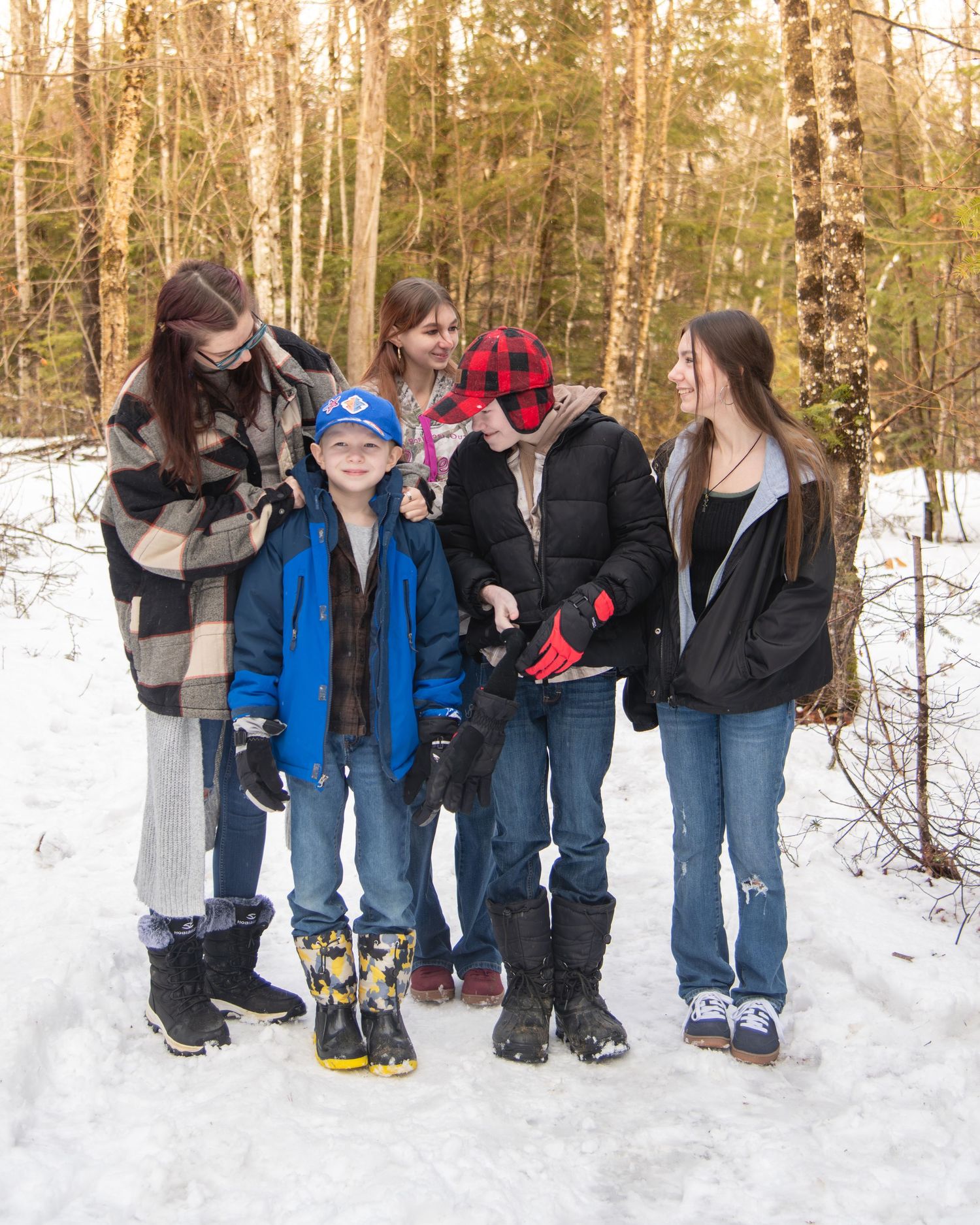A group photo series showing people's feet and legs standing in snowy winter conditions.