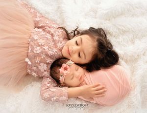 Dreamy portrait series showing someone lying on pink tulle fabric with delicate lace details.