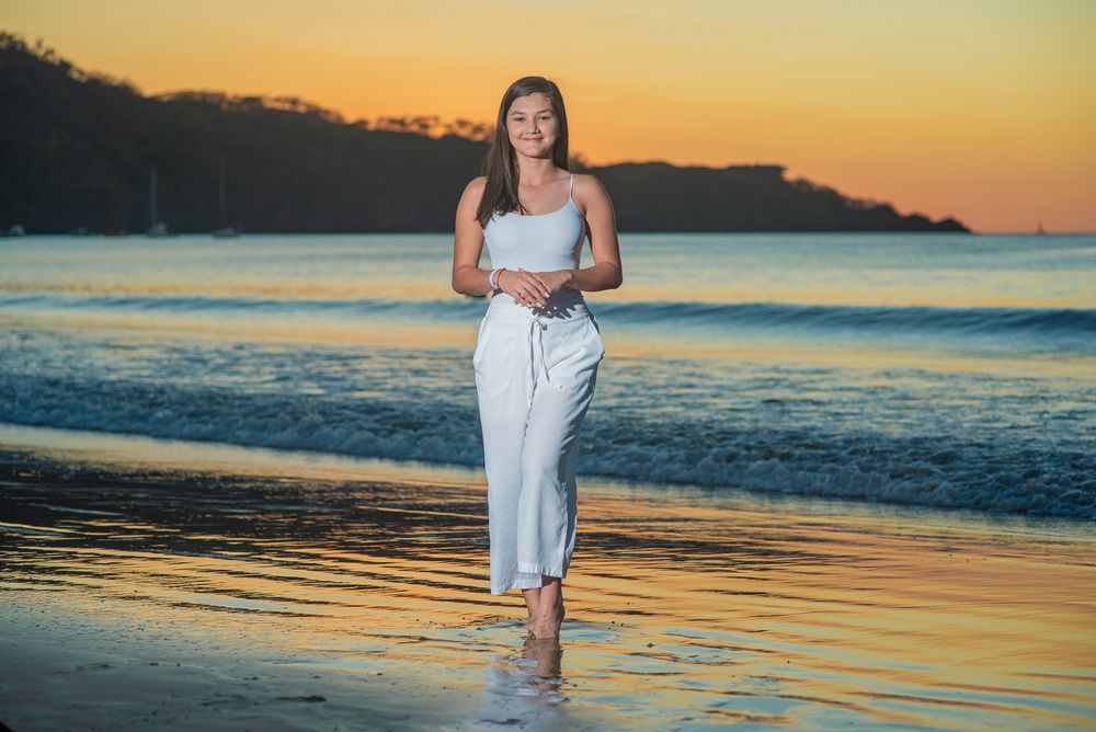 Scenic beach photography session at golden hour with reflections on wet sand and ocean waves.
