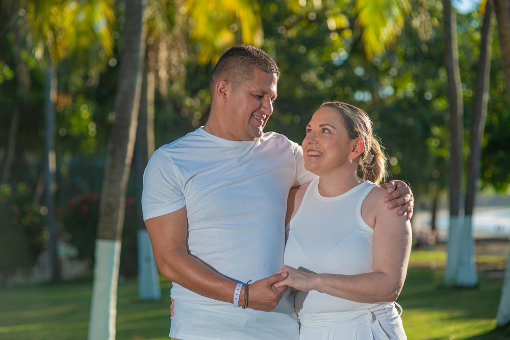 Family photoshoot in Guanacaste, in white outfits share a romantic moment together in a lush tropical garden setting.