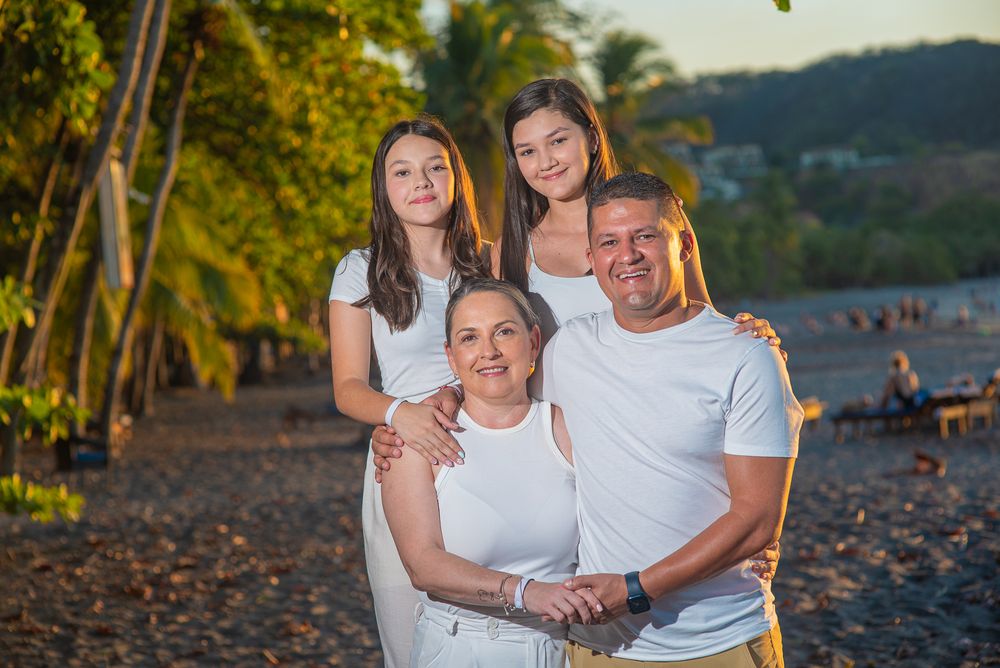 Family photoshoot in Guanacaste, casual beach portrait with palm trees and golden sunlight creating a warm tropical atmosphere.