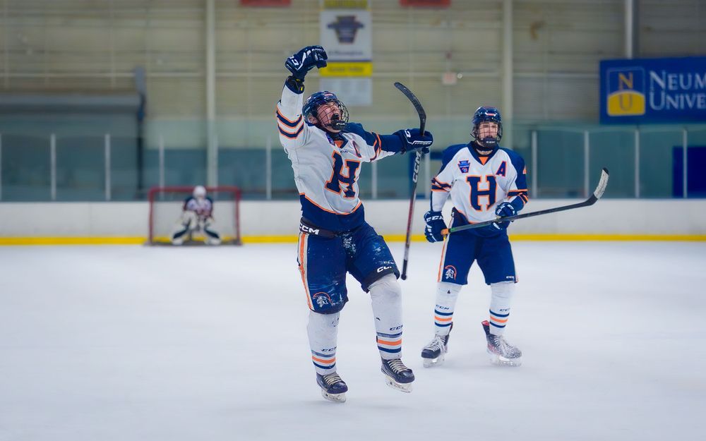 Hershey Trojans teammates celebrate a goal on the ice at IceWorks in the Flyers Cup Quarterfinals by SportsFox Photography, Hershey PA.