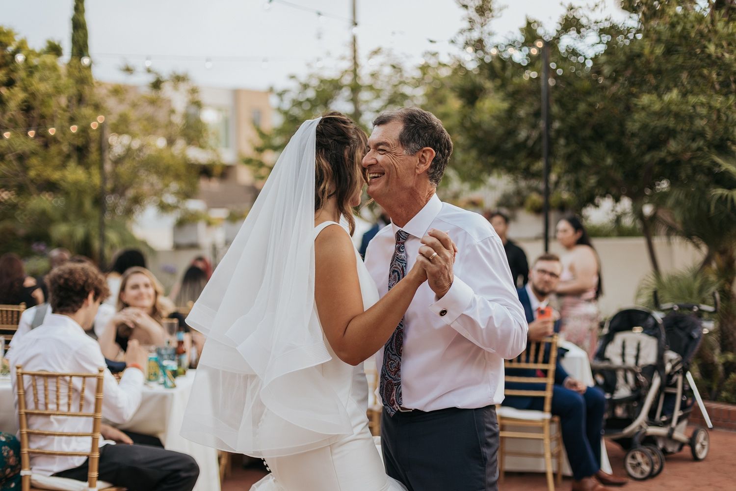 Father and bride share a joyful first dance at an outdoor wedding reception at Darlington House in La Jolla.
