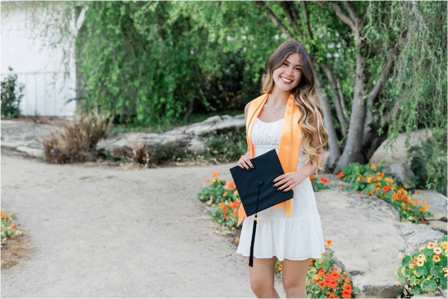 senior wearing white graduation dress with graduation cap during slo high senior photo session in san luis obispo