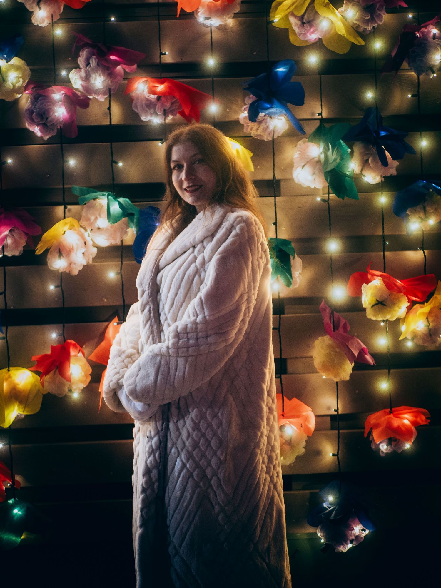 Artistic photo series against a wall of colorful string lights creating a dreamy bokeh effect in the darkness.