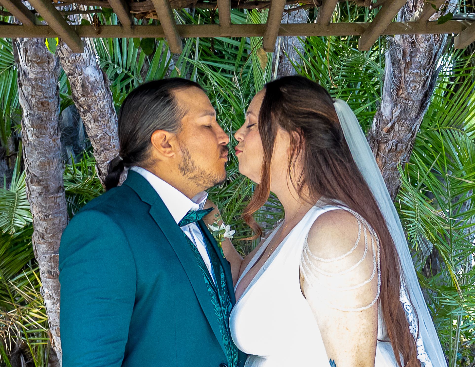 Intimate elopement kiss in a lush tropical garden setting captured by Zeus Holbrook San Diego Wedding Photographer